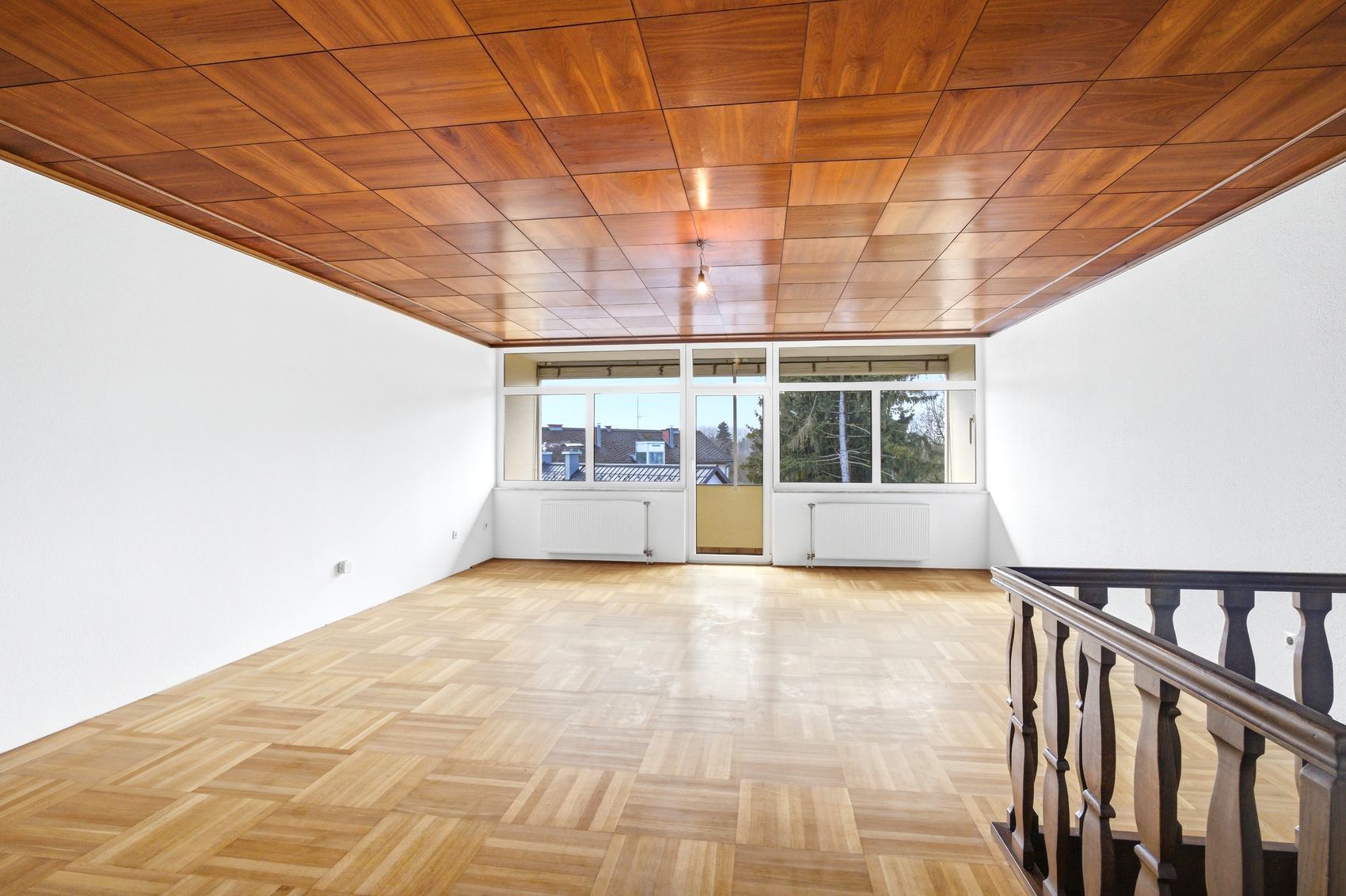 Wohnraum mit Holzdecke und Fensterfront