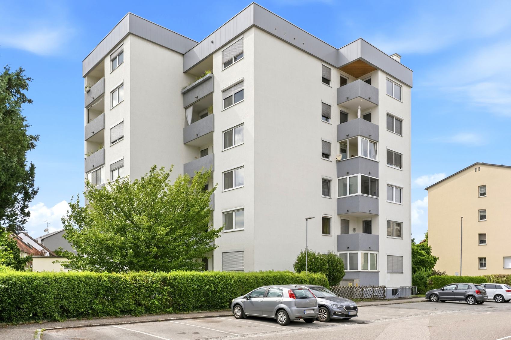 Wohnblock mit Balkonen und Parkplatz